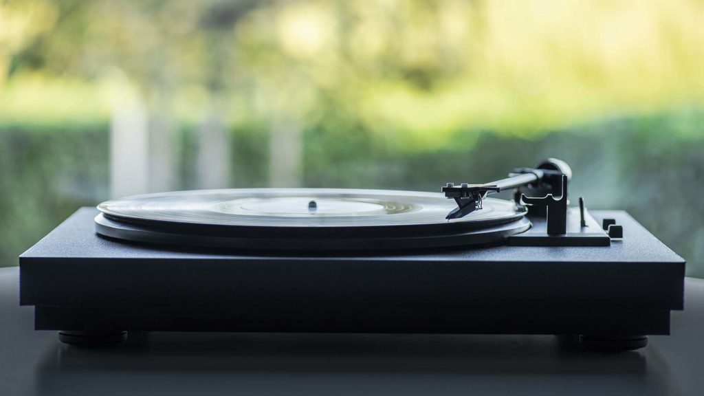 a side shot of a turntable with a vinyl record playing on it