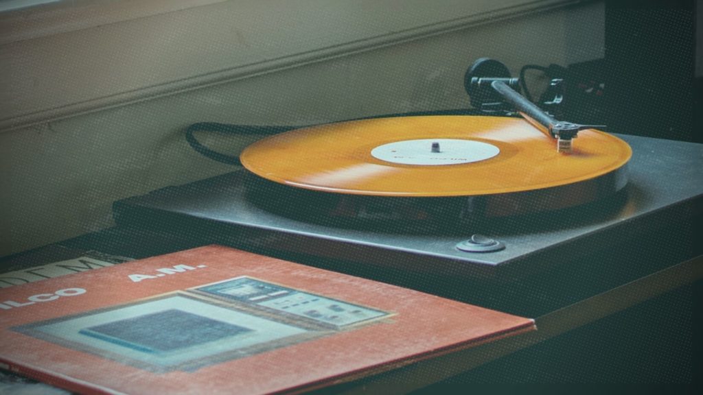 A picture of an orange record spinning on a record player.