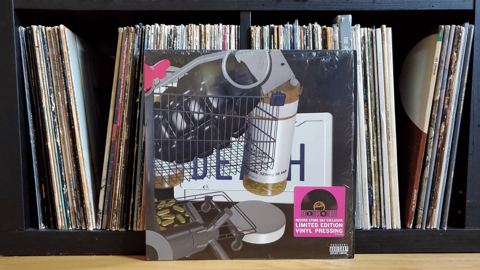 Death Grips Government Plates vinyl cover leaning against a shelf filled with other vinyl records