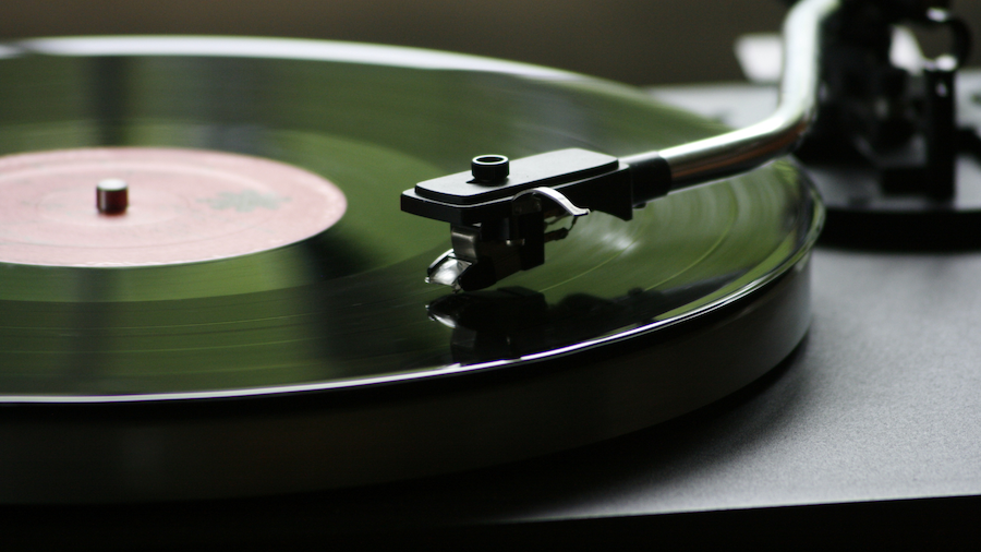 green vinyl record playing on a turntable