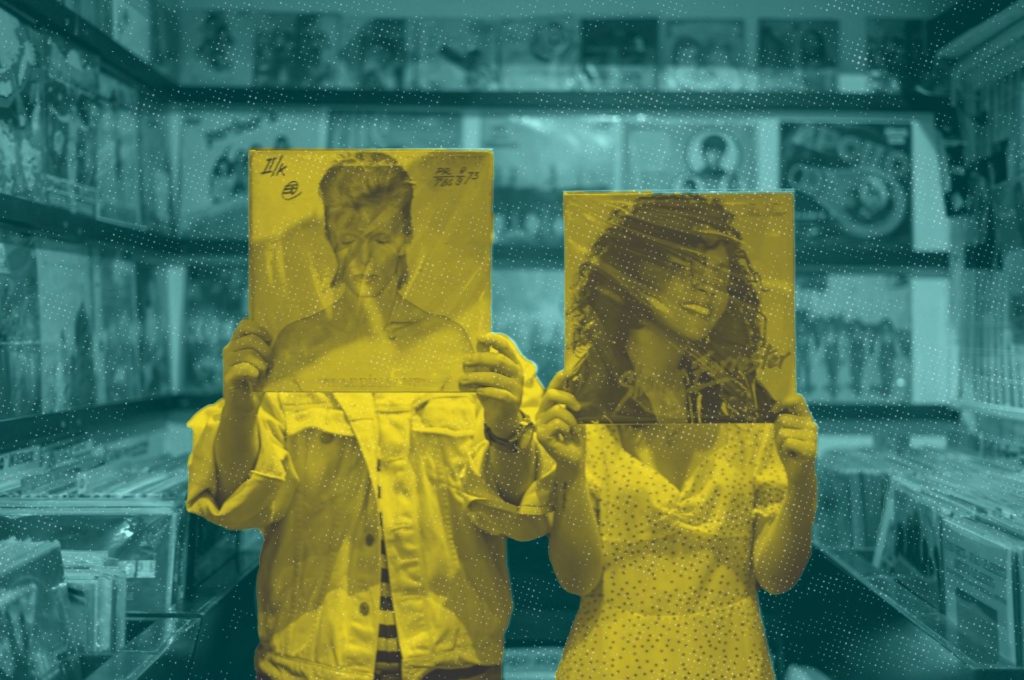 Two people standing in a record store, holding up records personifying the artists on the record cover.