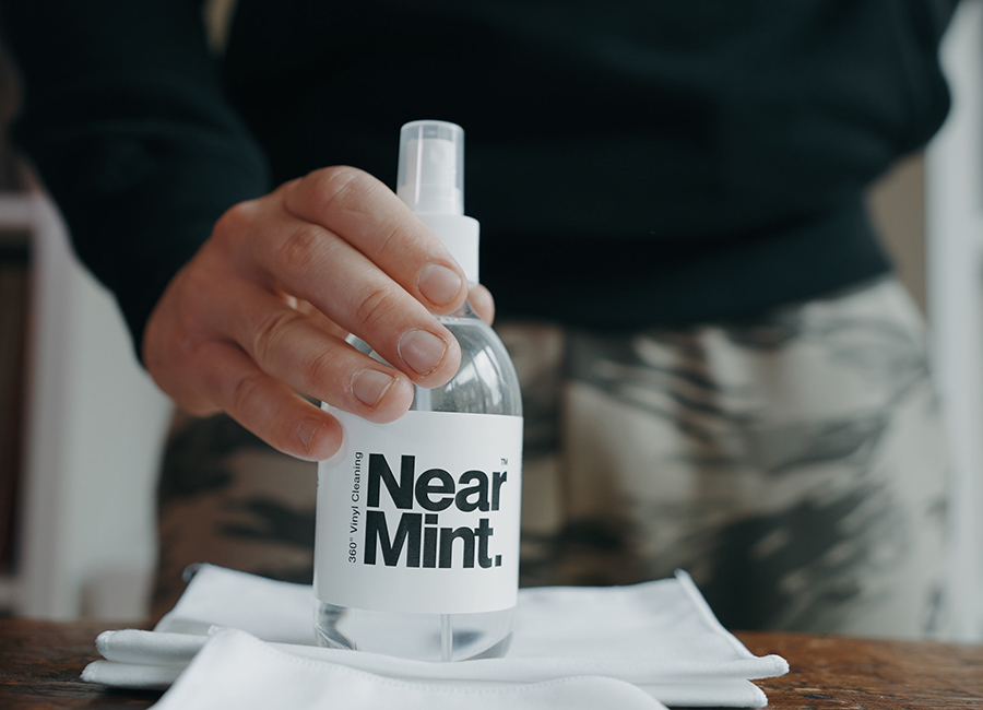 a hand holding a bottle of near mint vinyl record cleaner