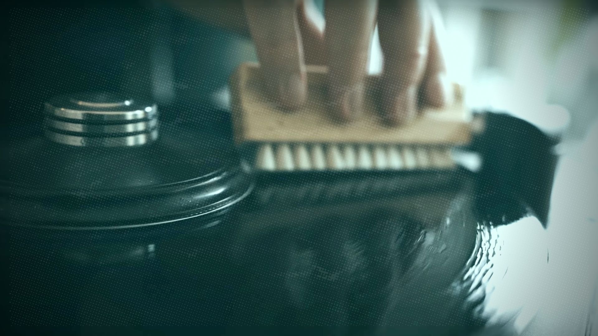 close-up of a person using a brush to clean a vinyl record on a turntable